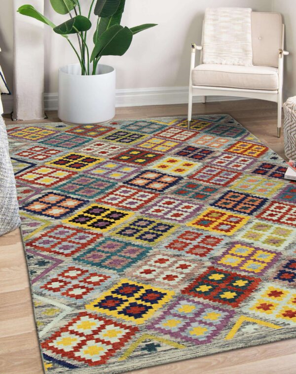 Multicolored flatweave rug featuring vibrant geometric diamond shapes on light wood flooring in a corner setting.