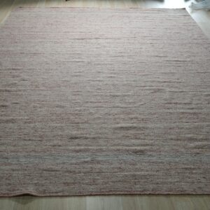 Textured, low-pile rug featuring dusty rose and cream horizontal striations on light wood flooring.