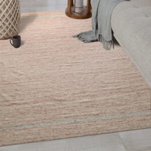 Heathered pink and cream low-pile rug lying on light plank flooring beneath a beige upholstered sofa.