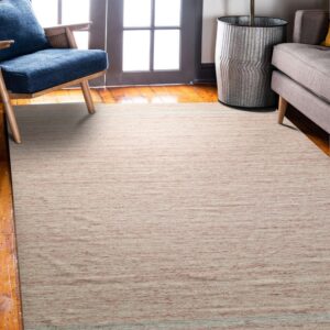 Low-pile dusty rose rug sits on wood floors beneath a blue armchair and a gray couch.