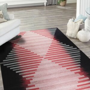 Black, red, and white woven rug with a central geometric pattern sits on light wood flooring.
