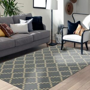 Geometric rug in blue-grey and beige zig-zag design lies on light hardwood flooring near a sofa.