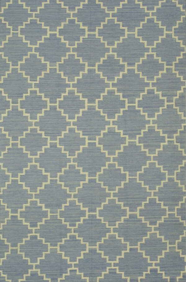 A low-pile blue rug features a repeating cream-colored geometric pattern of interlocking stepped diamonds.