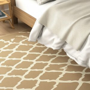 Tan and cream low pile rug with an irregular grid pattern next to a wooden bed and nightstand.