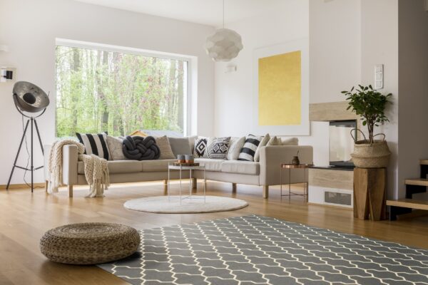 Gray flatweave rug with a light geometric lattice pattern in a bright modern living room.