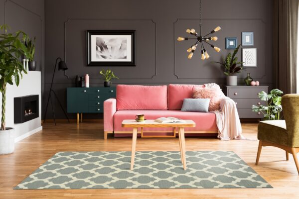 Geometric blue-gray and cream rug on wood floors centered in a dark, colorful living room.