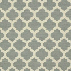 Woven rug featuring a cream trellis pattern against a textured dusty blue-gray background.