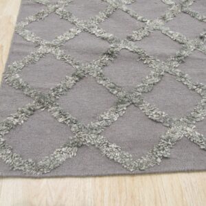 Gray rug featuring a raised, light gray shaggy diamond lattice pattern on light wood flooring.