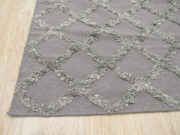 Gray rug featuring a raised, light gray shaggy diamond lattice pattern on light wood flooring.