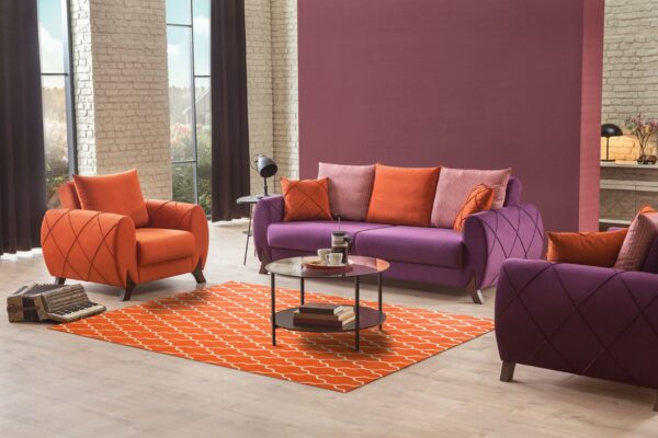 Orange rug with white geometric trellis pattern anchors a vibrant living room with purple seating and and brick walls.