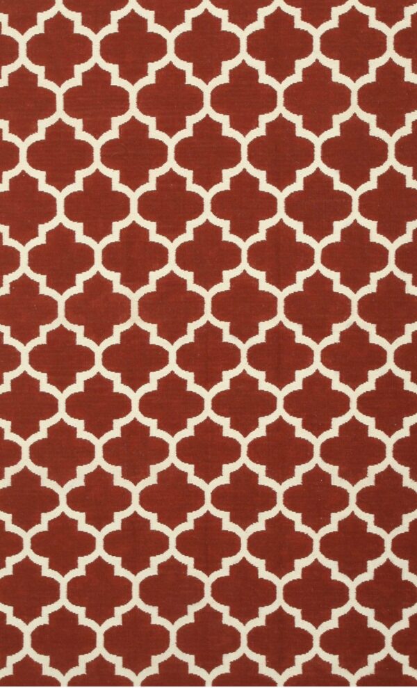 Flatwoven rug featuring a repeating cream quatrefoil trellis pattern on a deep reddish-brown field.