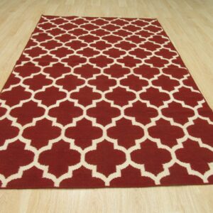 Low pile burgundy rug featuring a cream geometric quatrefoil pattern on light plank flooring.