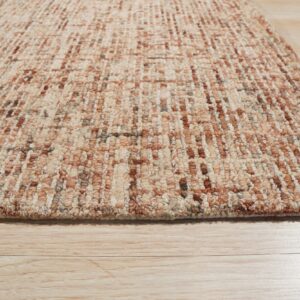 Textured loop pile rug in beige, rust, and brown colors lying on light wood flooring.