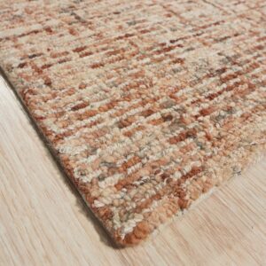Chunky textured rug featuring mottled beige and rust horizontal stripes rests on light wooden flooring.