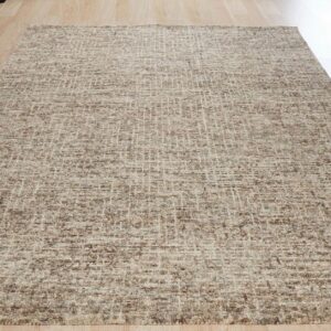 A textured beige and brown area rug with a subtle grid design sits on light wood planks.