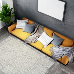 A rectangular light gray rug with an all-over chevron pattern rests on dark wood flooring.