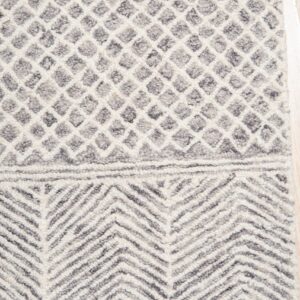 The shaggy gray and cream rug displays diamond trellis and bold chevron bands on light wood flooring.