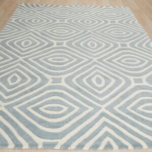 Blue and white rug with concentric diamond motifs and carved pile rests on light wood planks.