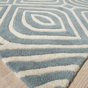 Textured light blue and cream rug featuring a carved geometric pattern resting on light wood flooring.