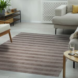 A low-pile taupe and brown striped rug anchors a modern living room with light neutral furniture.