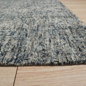 Chunky textured rug in blended blue and off-white colors on light hardwood planks.