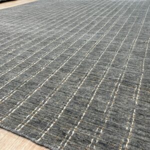 Gray textured rug with thin vertical white and beige stripes rests on light wooden flooring.