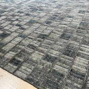Textured gray rug featuring a mottled, alternating rectangular grid pattern on light wood floor.