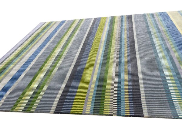 Textured rug featuring narrow vertical stripes of blue, green, yellow, and multiple shades of gray.