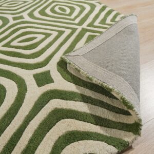 Textured green and cream rug with a geometric pattern, partially folded on light wood flooring.