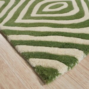Close-up of a shaggy green and cream geometric rug resting on light blonde plank flooring.