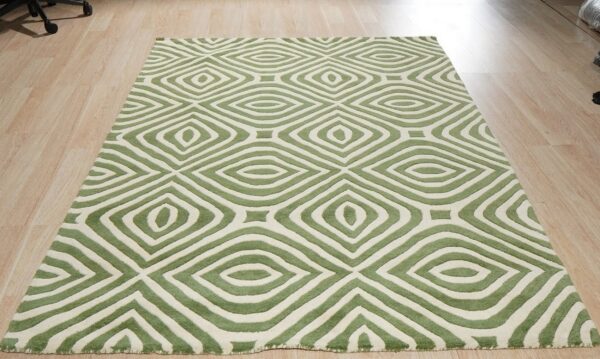 Textured green and off-white rug displaying concentric geometric diamond shapes on light wood flooring.
