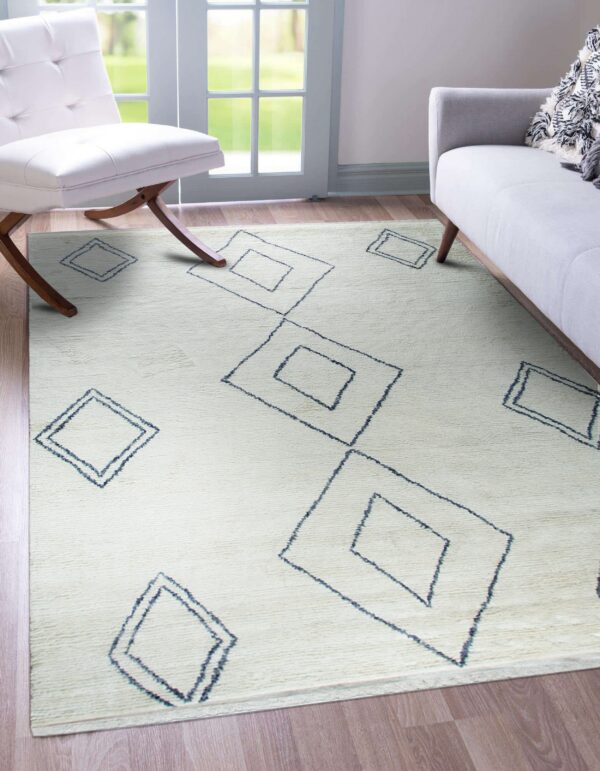 Ivory textured rug featuring scattered navy outlined diamonds, set beneath a white chair and gray sofa.