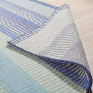Rug with multicolor blue, lavender, and cream stripes is partially rolled on light hardwood flooring.