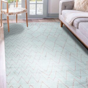 Pale blue rug featuring thin orange geometric lines on wood flooring, next to a chair and gray sofa.