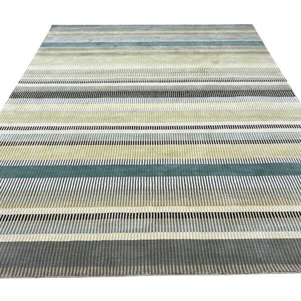 Low-pile rug with wide horizontal stripes of teal, yellow, black, and various shades of gray segments.