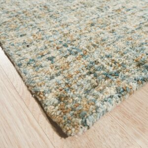Chunky high-pile rug featuring mixed blue, tan, and cream colors on light wood plank flooring.
