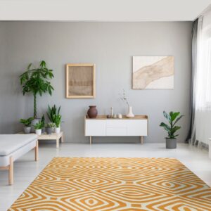 A bright orange and white geometric rug anchors a contemporary room with gray walls and wood furniture.