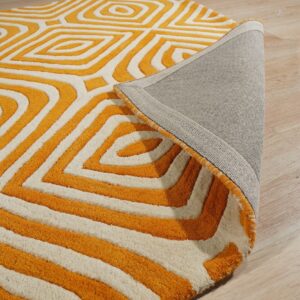 Plush orange and white rug with a sculpted geometric pattern, revealing the gray backing on light wood.