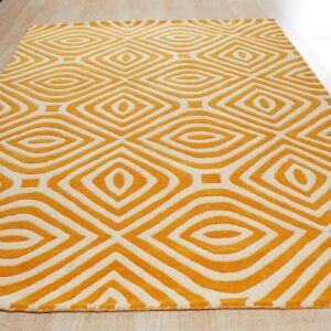Orange and white rug with a deeply carved geometric diamond pattern sits on light wood plank flooring.