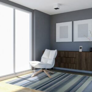 Thinly striped rug in varying shades of blue, gray, and beige on a light hardwood floor.