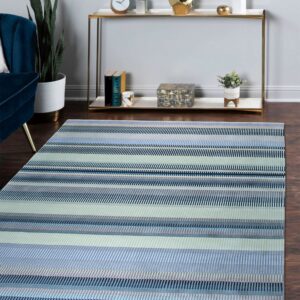 Striped blue, gray, and pale green rug on a dark wood floor beside a console table and velvet chair.