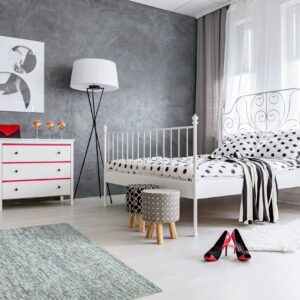 Blue and gray distressed rug and a white shaggy accent rug in a modern bedroom.