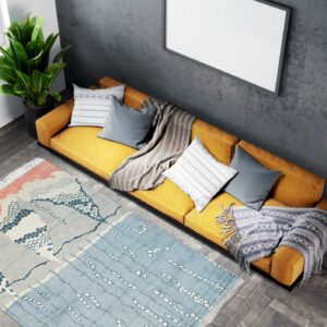 Abstract coral, gray, and blue rug placed on dark wood floors near a mustard yellow sofa.