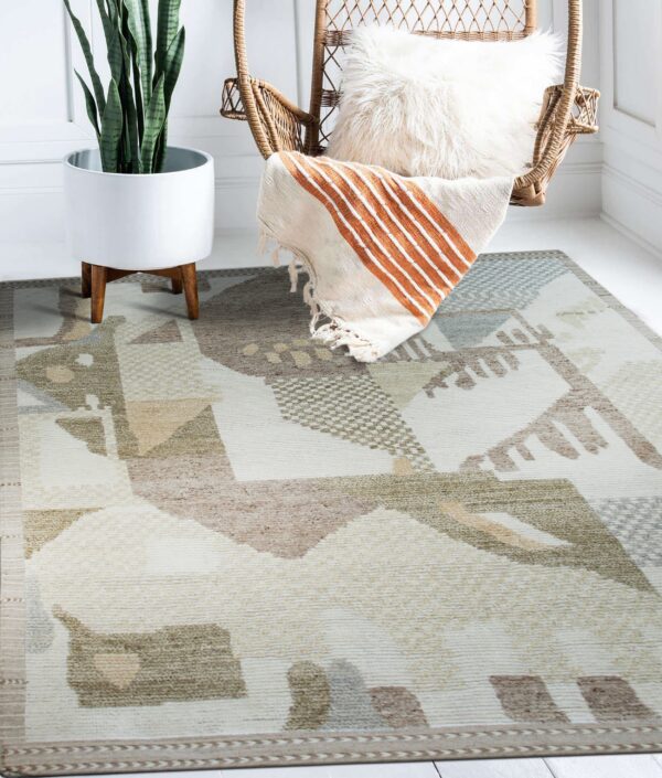 Geometric cream, tan, and olive green rug placed beneath a wicker chair and a potted snake plant.
