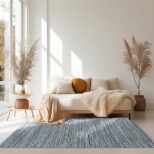 A mottled blue-gray rug with subtle vertical linear texture anchors a bright room below a neutral couch.