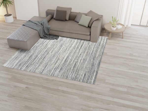 Streaked gray and white rug grounding a neutral living space with a sectional couch.