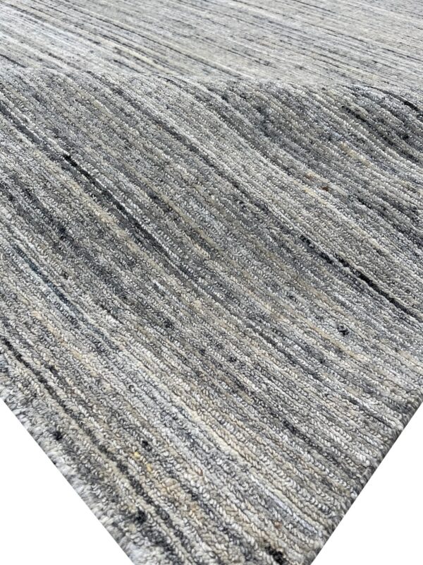 Heathered gray rug with a chunky, ribbed texture, featuring distinct vertical or diagonal rows of loops.