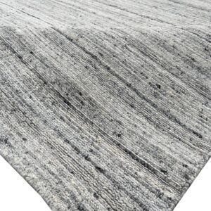 Thick gray and white textured rug with diagonal ribbing and speckled, heathered yarn.