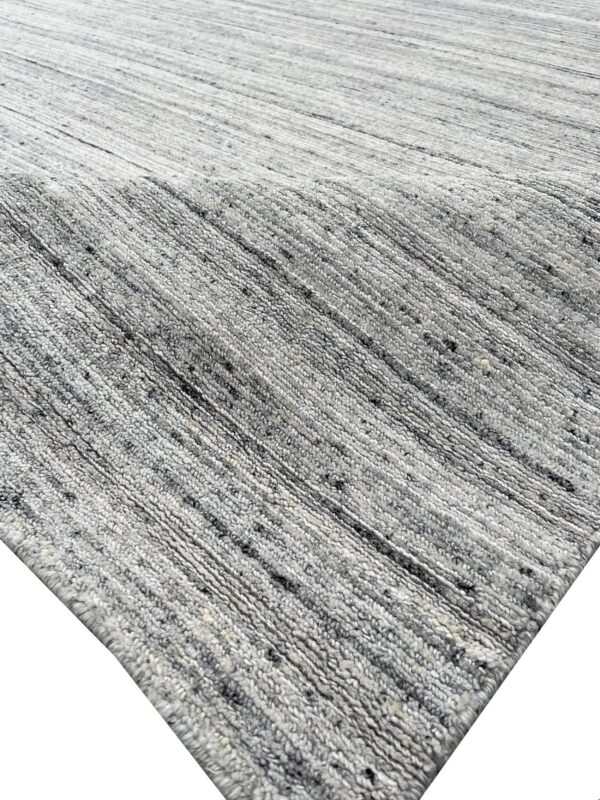 Thick gray and white textured rug with diagonal ribbing and speckled, heathered yarn.