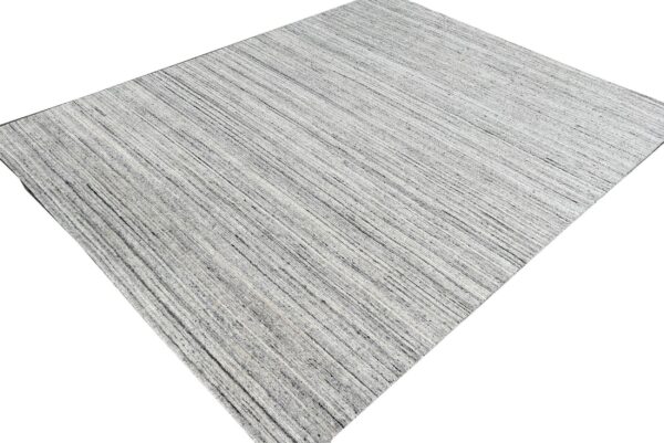 Rectangular rug featuring a striated design of fine gray, charcoal, and white linear texture.